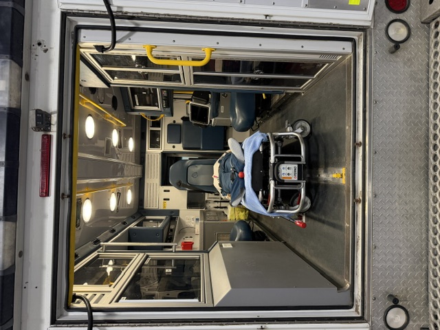Ambulance training bay with stretcher and clinical equipment inside emergency vehicle