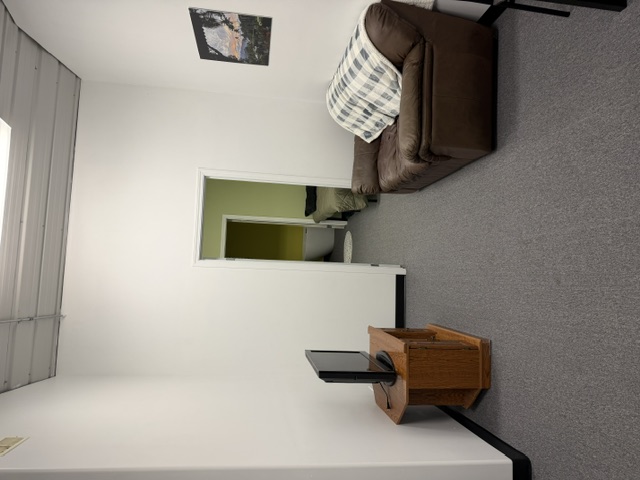 Sharalife quiet lounge with sofa, television, and adjoining rest room