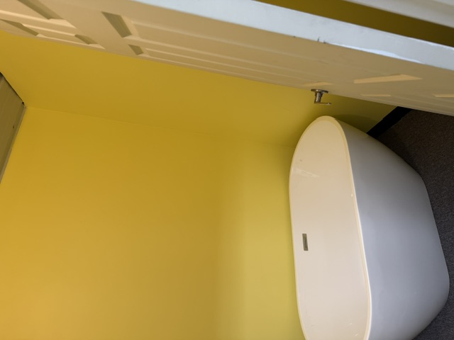 Sharalife private bathroom with freestanding soaking tub and bright yellow walls