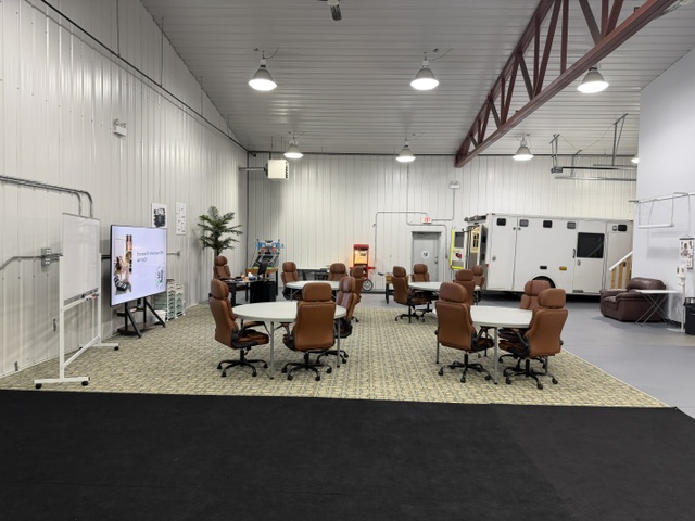 Sharalife training classroom with round tables, presentation screen, lounge, and ambulance bay